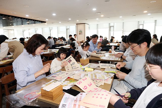 사진2. 대우건설 임직원과 가족들이 점자 KIT를 배부받아 교구를 제작하고 있다..jpg